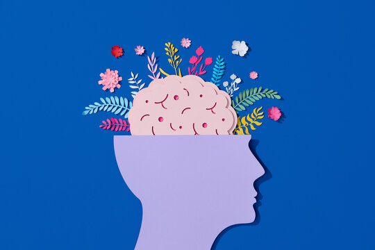 Paper cut displaying human head with flower-filled brain