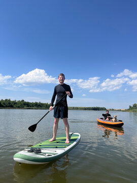 Friends Having Fun on a Lake wit a Dog at Summertime