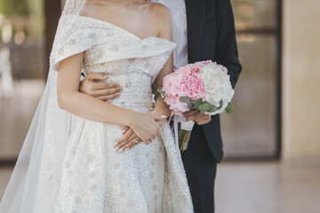 the bride and groom with a bouquet of flowers. Newlyweds at wedding day, wedding couple with wedding bouquet of flowers, bride and groom. Luxury bridal dress and bouquet of flowers. 