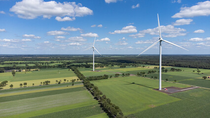 Landscape photo of two wind turbines in meadow farming field. Green renewable energy, global warming, climate change, sustainability, farm land concept. 