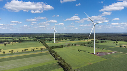 Landscape photo of two wind turbines in meadow farming field. Green renewable energy, global warming, climate change, sustainability, farm land concept. 