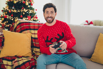 Portrait of nice young man play videogames christmas holiday time flat indoors