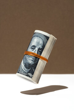 American dollar money roll hovering on brown and white background