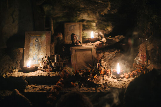 Candlelit Hindu Shrine Surrounded by Statues and Offerings