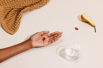 Hand With Gel Capsule and Pear