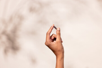 Hand Holding Pill Against Blurred Background