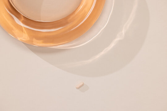 Vitamin B Pill on Light Surface Next to Plate 
