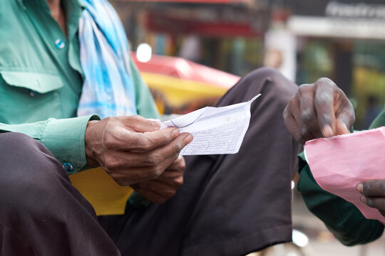 Man Examining Paperwork in Street Market