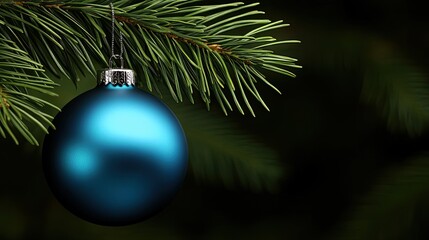 A close-up view of a dark blue Christmas ornament elegantly suspended from a green evergreen branch, showcasing intricate details and vibrant colors against a dark backdrop