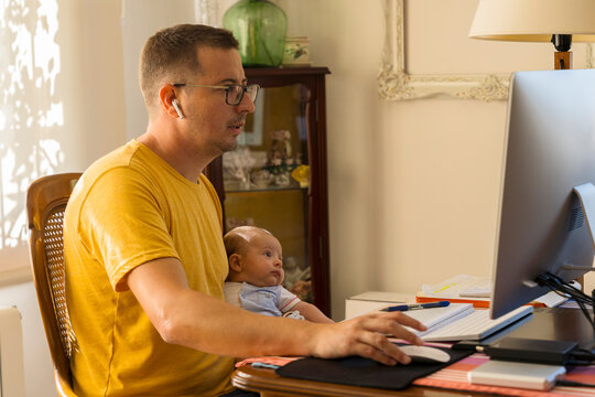 Dad sitting at computer with baby 