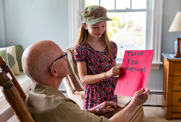 Young Girl hands card portrait thanking veteran tribute at home