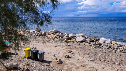 4 containers for sort rubbish and recycle stand on the beach, on the seashore, ocean or lake. Caring for the environment.