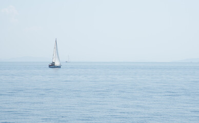 Fototapeta premium Sailboat with mast and open sails is sailing on a calm sea. Greek Islands, Ionian Sea