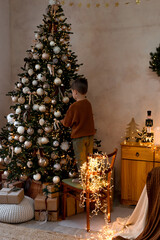 A Child Joyfully Decorating a Beautiful Christmas Tree with Warm Lights and Colorful Ornaments