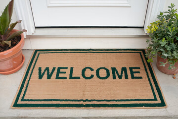 a mat on the threshold with the inscription ‘welcome