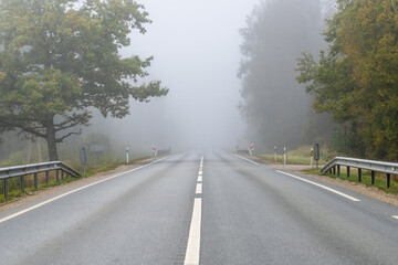 Asphalted road covered in fog