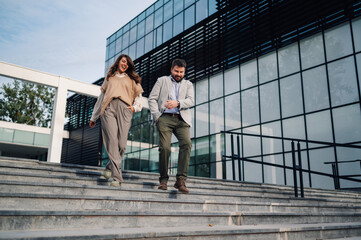 Business people walking down stairs in front of office building