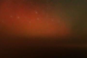 A peaceful night sky filled with faint stars and a soft red aurora glow near the horizon. The cosmic scene blends dark space with atmospheric colors, creating a dreamy, tranquil view.