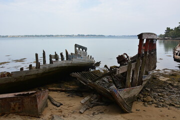épave de bateau en bois avec ossature en bois échoué sur une plage bretonne avec la mer en...