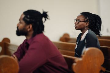 People sitting in church pew attending religious service