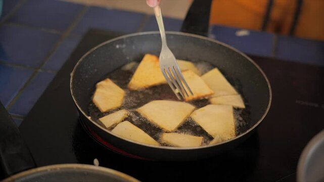 Man frying breadfruit in a pan (Martinique)