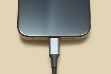  Turned off smartphone connected to usb cable on pastel background