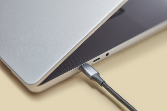 Black line cable inserted in side port of personal laptop