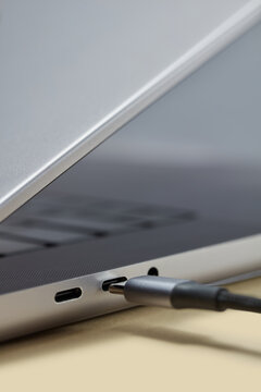 Close up type c cable getting plugged in silver laptop