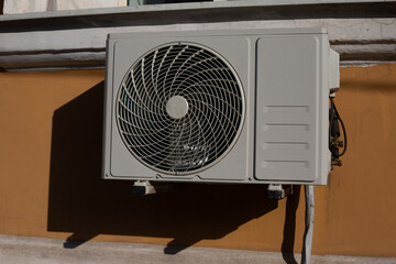 Photo of an air conditioner on wall of building, fan for taking air from the street and cooling...