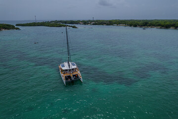 Aerial view of a beautiful catamaran in the turquoise waters of Bora Bora island and Island de...