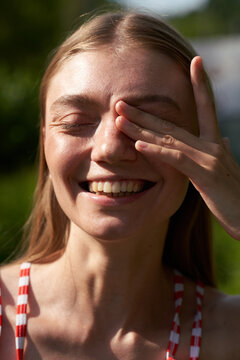 Young Woman Posing Outdoors With Hand Over Eye