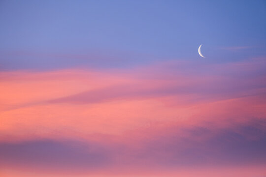 Crescent moon during beautiful pink sunrise