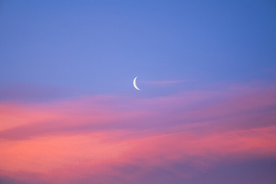 Crescent moon during beautiful pink sunrise