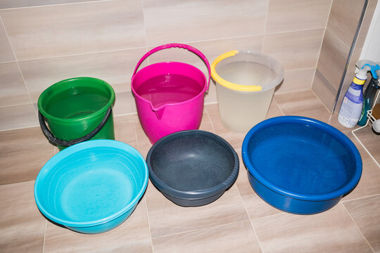 Colorful buckets full of water. Water shortage, shut-off, drought