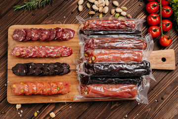 Assorted gourmet salami slices with nuts and spices on board, charcuterie and deli platters