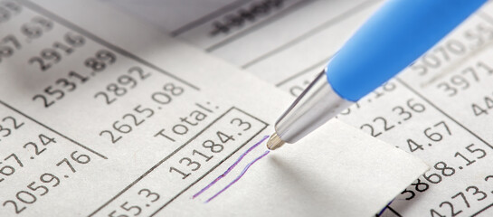 Accounting document with pen, money, coins and checking financial chart. Concept of banking, financial report and financial audit.