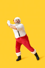 Funny Santa Claus dancing on yellow background