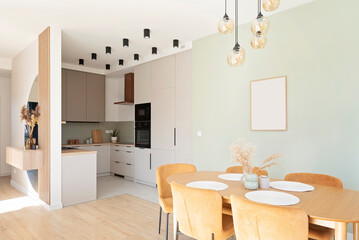 Dining room with table and mustard chairs in stylish design in new apartment with kitchen. Cozy an luxurious room with modern furniture. Real estate.	