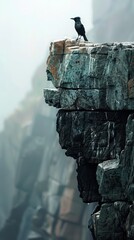 A wild bird majestically perches on a massive rock overlooking rugged cliffs in misty wilderness