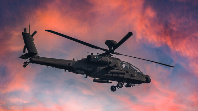 modern attack helicopter in the sunset sky.AH 64E Apache.
