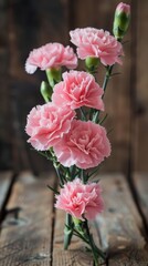 Elegant pink carnations on a rustic wooden table create a charming floral arrangement