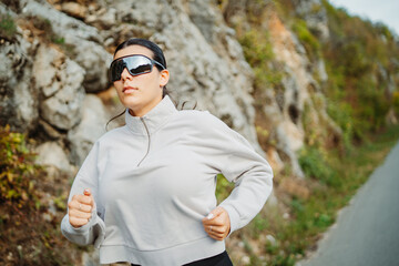 Young caucasian woman running or jogging on the country road	