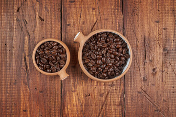 Freshly roasted coffee beans on wooden table; close-up