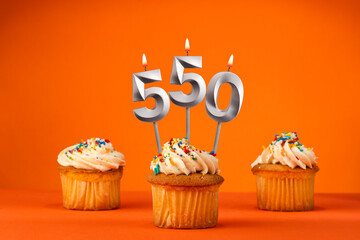 Candle number 550 - Celebration with birthday cupcake on orange background