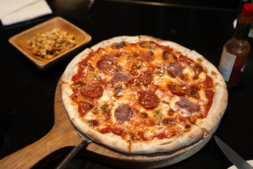 Pepperoni pizza and peanuts on a restaurant table
