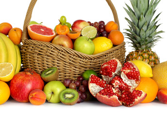Many different fresh fruits in wicker basket isolated on white