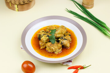 Ayam rica-rica, Indonesian traditional spicy chicken with spicy sauce and basil leaves. Isolated background.