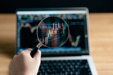 Businesswomen use magnifier glass find stock in stock markets, uptrends, growth economics, business strategy development, and opportunities for investment, take profit from funds, Financial Analyst.