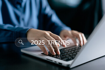 Businesswomen typing the keyword 2025 trends search in engine bar wording for marketing monitor and...