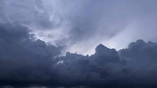 A dramatic dark cloud moves across the sky, partially obscuring the sun. Gray cloud, and bad weather.